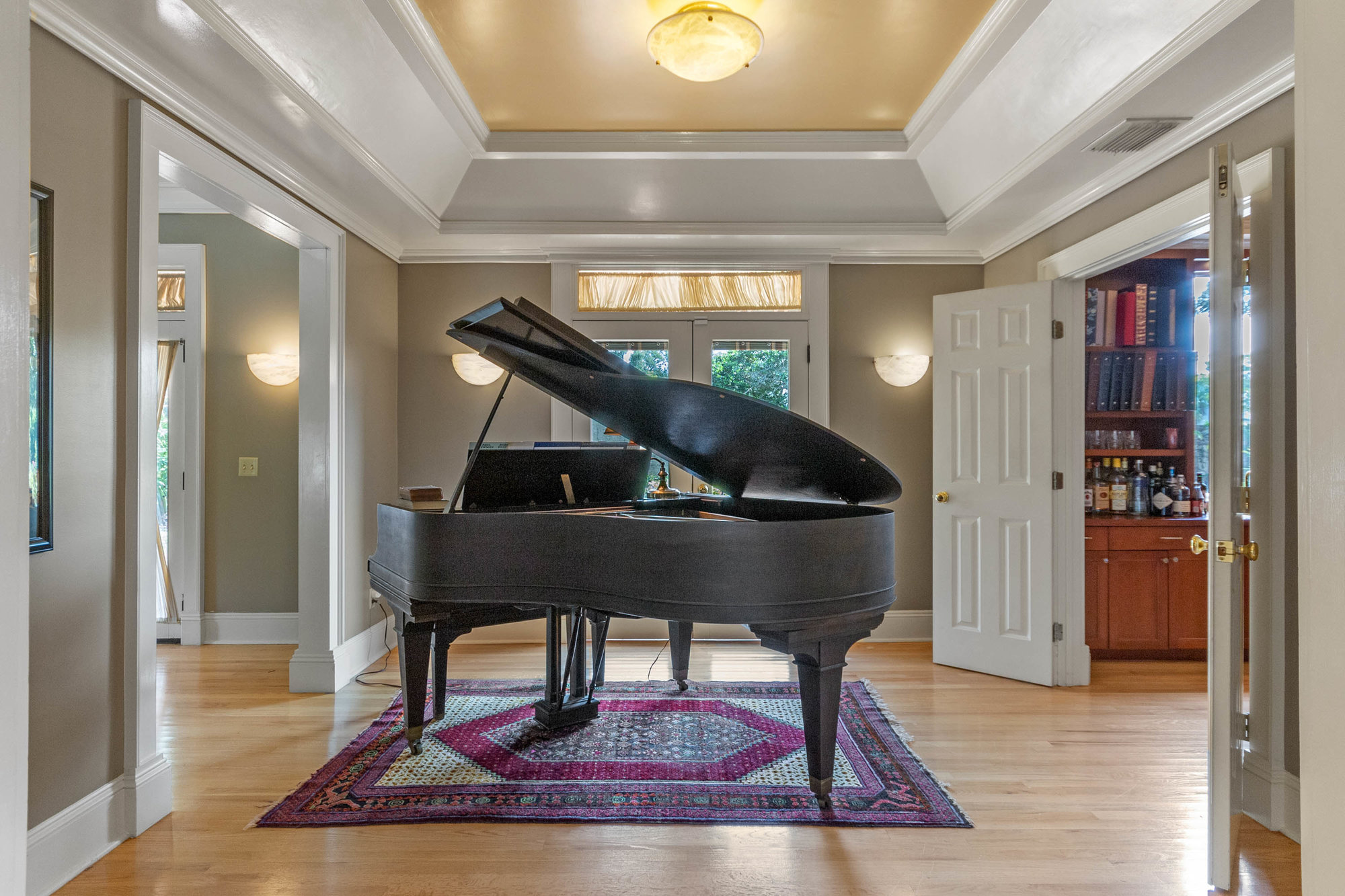 room with black grand piano in center